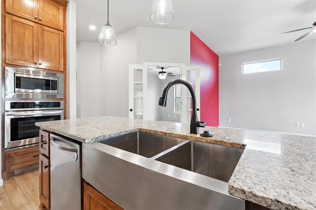 9233 NW 91st St, Yukon, OK 73099 - kitchen with stainless steel appliances, a ceiling fan, brown cabinets, and hanging light fixtures