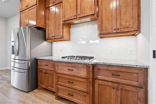 9233 NW 91st St, Yukon, OK 73099 - kitchen with appliances with stainless steel finishes, brown cabinets, and backsplash