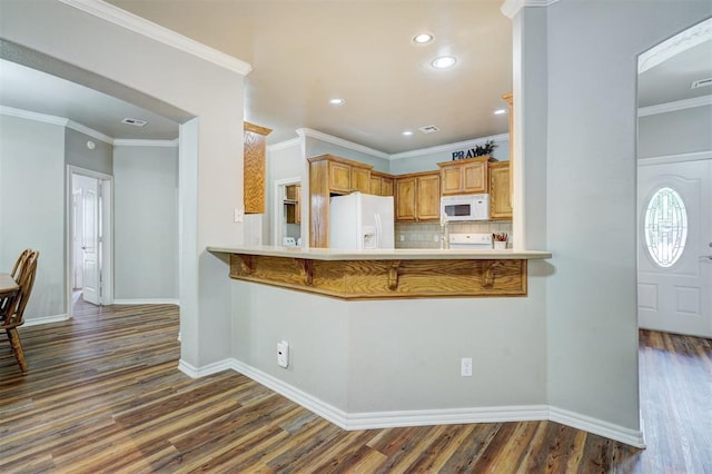 2209 Cedar Pointe Ct, Edmond, OK 73003 - kitchen with white appliances, decorative backsplash, dark wood-type flooring, a kitchen breakfast bar, and recessed lighting