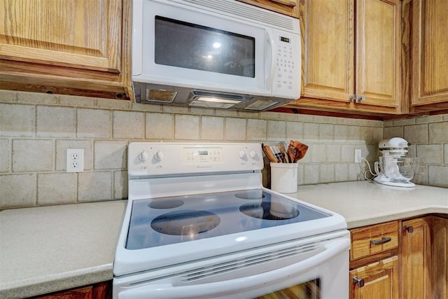 2209 Cedar Pointe Ct, Edmond, OK 73003 - kitchen featuring white appliances, light countertops, tasteful backsplash, and brown cabinetry