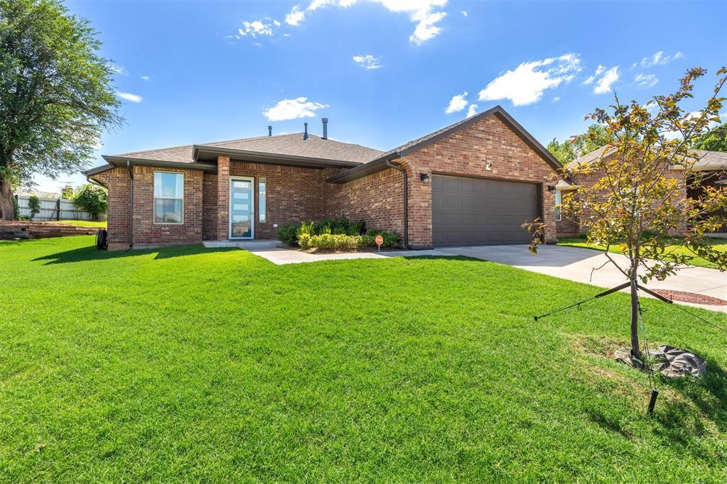 302 Tuscany Cir, Noble, OK 73068 - single story home featuring an attached garage, concrete driveway, a front lawn, and brick siding