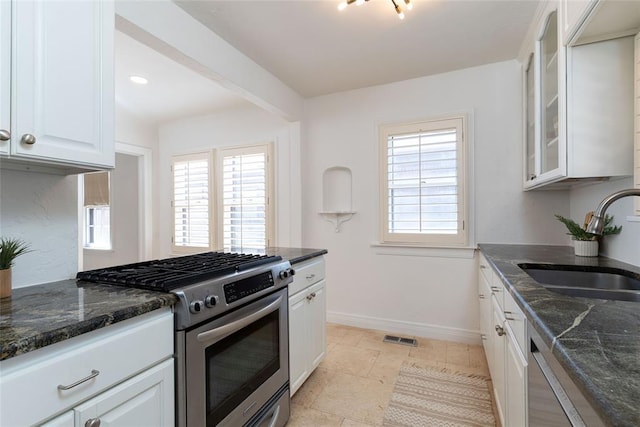 225 NW 35th St, Oklahoma City, OK 73118 - kitchen featuring stainless steel appliances, dark stone counters, white cabinets, and glass insert cabinets