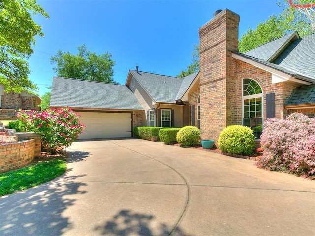 402 Hunters Ct, Edmond, OK 73034 - view of front of property with a garage, concrete driveway, a chimney, brick siding, and a shingled roof
