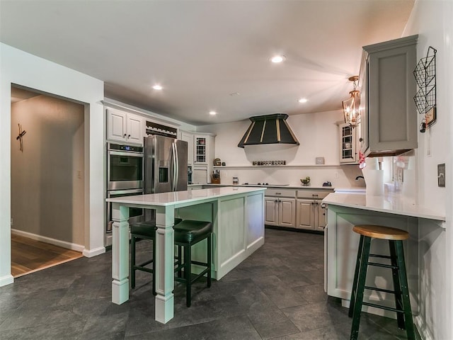 402 Hunters Ct, Edmond, OK 73034 - kitchen with appliances with stainless steel finishes, range hood, a kitchen bar, glass insert cabinets, and light countertops