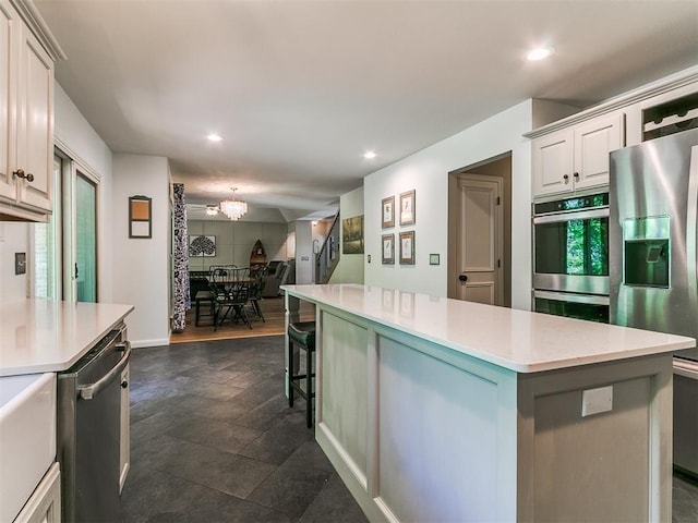 402 Hunters Ct, Edmond, OK 73034 - kitchen featuring stainless steel appliances, a center island, light countertops, recessed lighting, and a chandelier