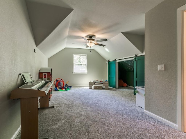 402 Hunters Ct, Edmond, OK 73034 - playroom featuring ceiling fan, carpet, a textured wall, a barn door, and lofted ceiling