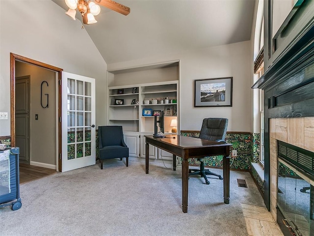 402 Hunters Ct, Edmond, OK 73034 - home office featuring carpet, a tiled fireplace, a ceiling fan, built in shelves, and high vaulted ceiling