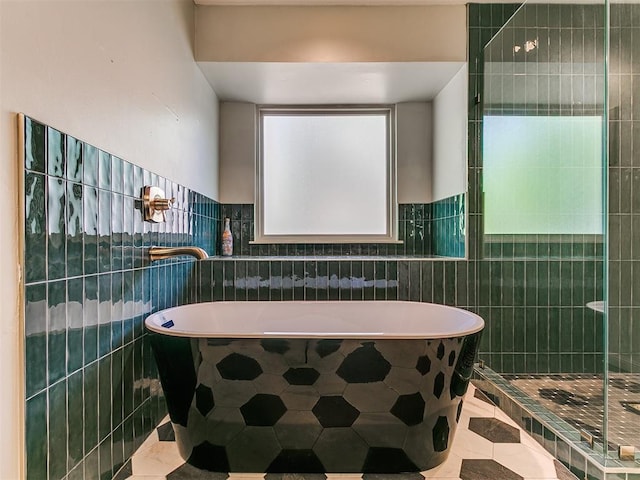402 Hunters Ct, Edmond, OK 73034 - bathroom featuring tile patterned flooring, tile walls, a soaking tub, and a shower stall