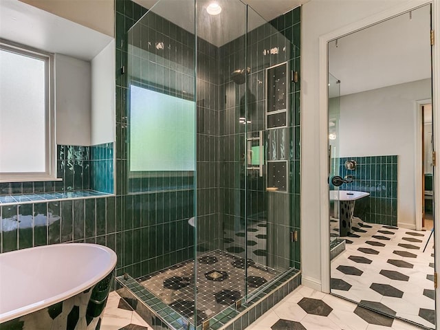 402 Hunters Ct, Edmond, OK 73034 - bathroom featuring tile walls, a freestanding tub, a stall shower, and tile patterned floors