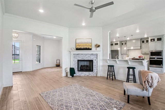 4204 Chesterfield Pl, Oklahoma City, OK 73179 - living room with ornamental molding, a ceiling fan, light wood finished floors, a fireplace, and recessed lighting