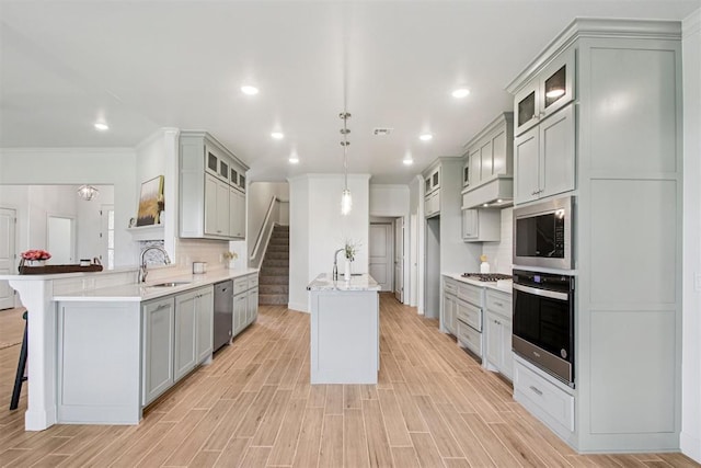 4204 Chesterfield Pl, Oklahoma City, OK 73179 - kitchen with appliances with stainless steel finishes, a peninsula, a kitchen bar, gray cabinetry, and glass insert cabinets