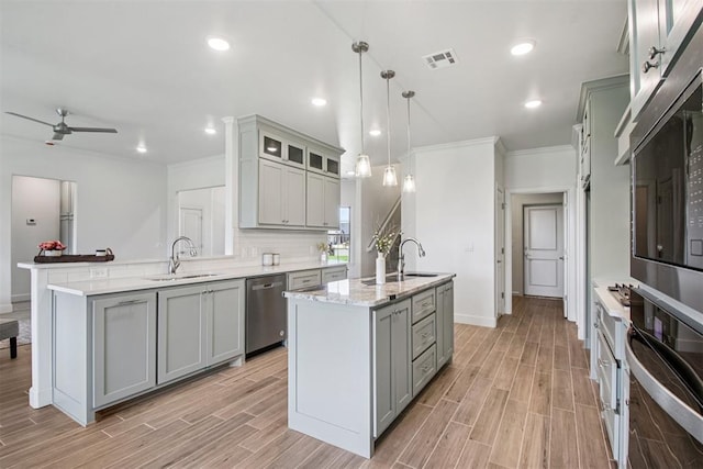 4204 Chesterfield Pl, Oklahoma City, OK 73179 - kitchen with stainless steel appliances, gray cabinetry, a ceiling fan, a peninsula, and light wood finished floors