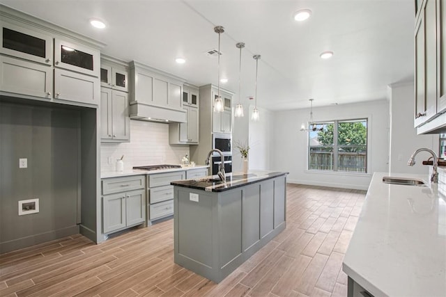 4204 Chesterfield Pl, Oklahoma City, OK 73179 - kitchen featuring gray cabinets, light wood-style flooring, light stone countertops, backsplash, and recessed lighting