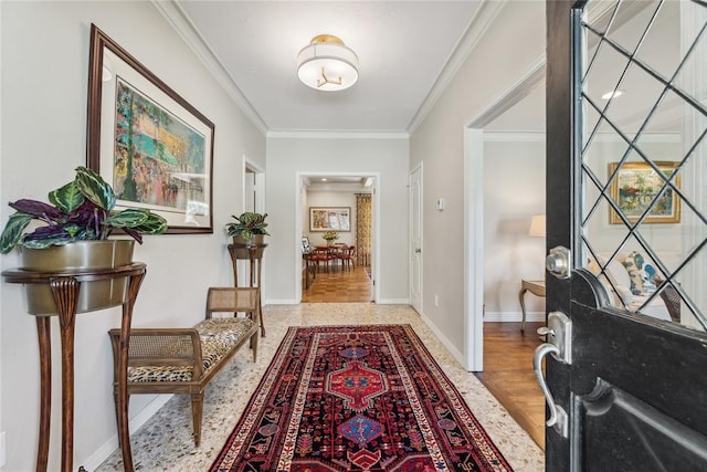 foyer entrance featuring ornamental molding and baseboards