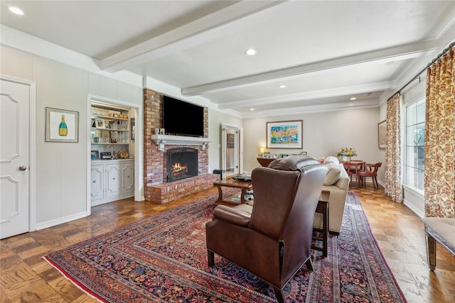 living area featuring a brick fireplace, beamed ceiling, recessed lighting, ornamental molding, and built in shelves