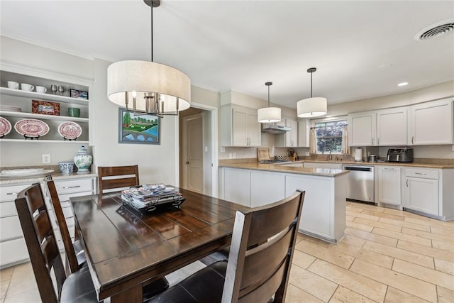 kitchen featuring stainless steel dishwasher, open shelves, white cabinets, crown molding, and hanging light fixtures