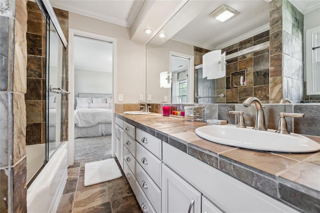 ensuite bathroom with ornamental molding, double vanity, stone finish floors, and bath / shower combo with glass door