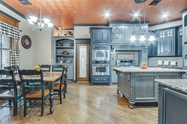 405 Kingsgate Rd, Yukon, OK 73099 - kitchen featuring stainless steel appliances, a chandelier, open shelves, light wood finished floors, and a kitchen island