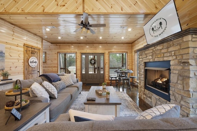 944 Camp Ranch Rd, Broken Bow, OK 74728 - living room with wood finished floors, ceiling fan, wood walls, a stone fireplace, and wooden ceiling