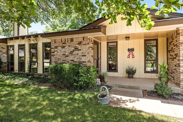 2408 Shady Tree Ln, Edmond, OK 73013 - entrance to property with board and batten siding, a lawn, a porch, and brick siding