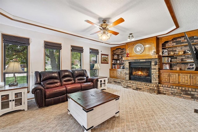 2408 Shady Tree Ln, Edmond, OK 73013 - living area featuring light colored carpet, a raised ceiling, a ceiling fan, and a brick fireplace