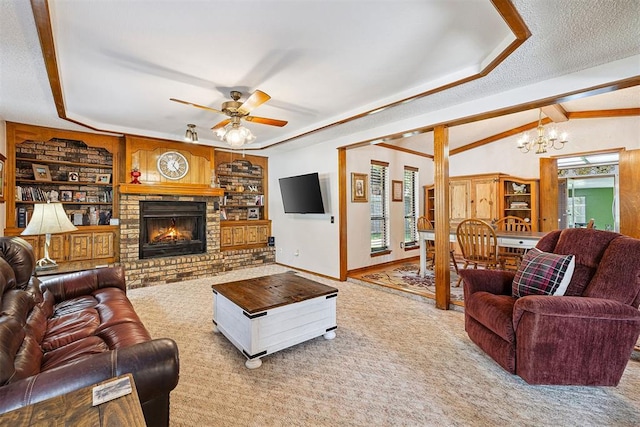 2408 Shady Tree Ln, Edmond, OK 73013 - living room featuring carpet flooring, a chandelier, built in shelves, ceiling fan, and a brick fireplace