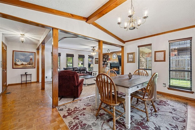 2408 Shady Tree Ln, Edmond, OK 73013 - dining room featuring a warm lit fireplace, a textured ceiling, a chandelier, ceiling fan, and crown molding