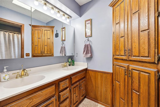 2408 Shady Tree Ln, Edmond, OK 73013 - bathroom with wainscoting, double vanity, and wooden walls