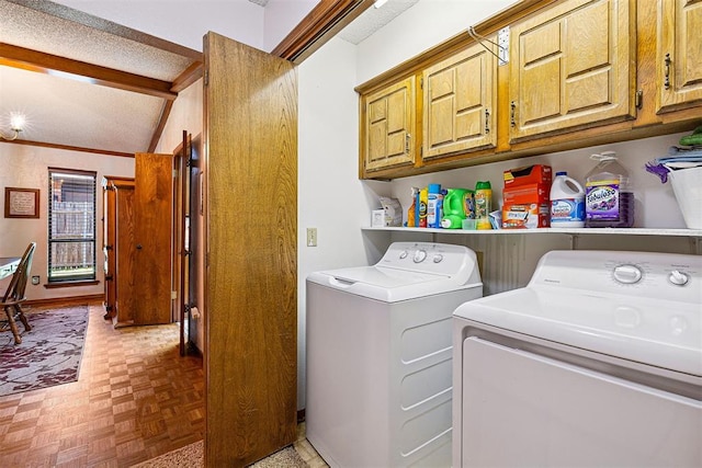 2408 Shady Tree Ln, Edmond, OK 73013 - laundry room featuring washer and clothes dryer, cabinet space, and a textured ceiling