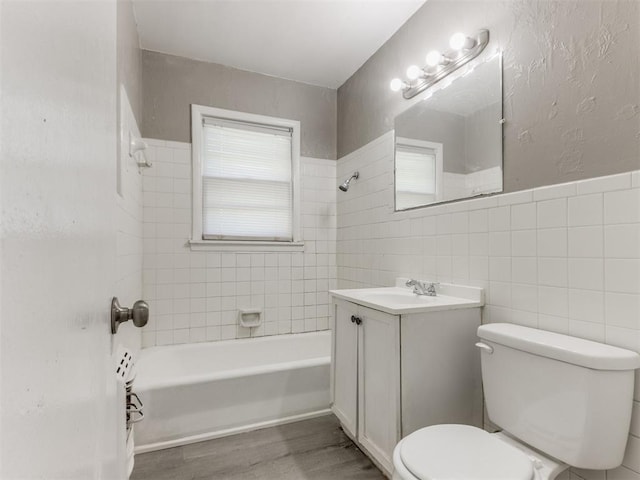 3320 NE 14th St, Oklahoma City, OK 73117 - full bath featuring vanity, wood finished floors, tub / shower combination, and tile walls