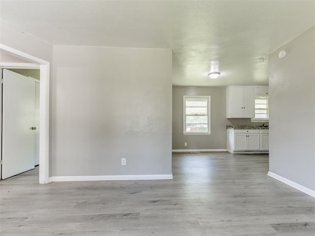 3320 NE 14th St, Oklahoma City, OK 73117 - unfurnished living room featuring baseboards and light wood-type flooring