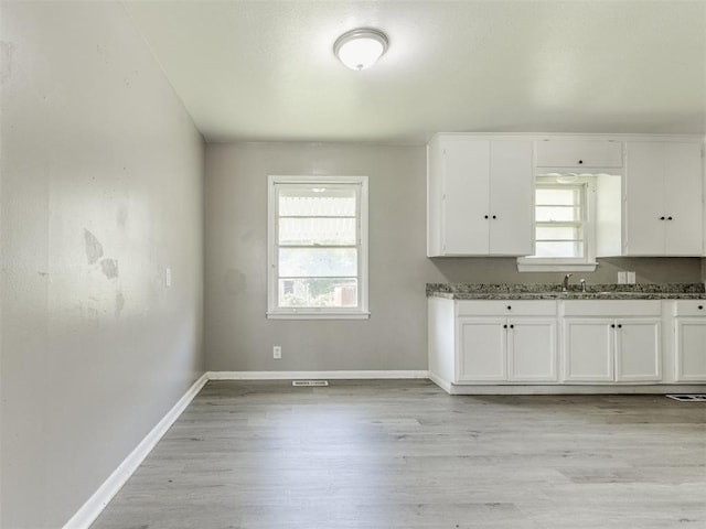 3320 NE 14th St, Oklahoma City, OK 73117 - kitchen featuring plenty of natural light, white cabinetry, and light wood-style flooring