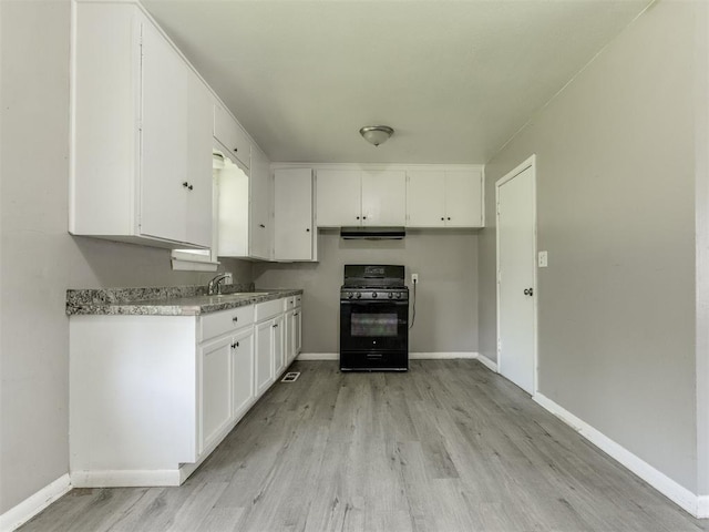 3320 NE 14th St, Oklahoma City, OK 73117 - kitchen with black range with gas stovetop, light wood-type flooring, white cabinetry, and light countertops
