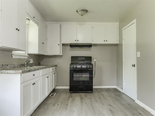 3320 NE 14th St, Oklahoma City, OK 73117 - kitchen featuring black gas range, light wood-style floors, white cabinetry, under cabinet range hood, and light countertops