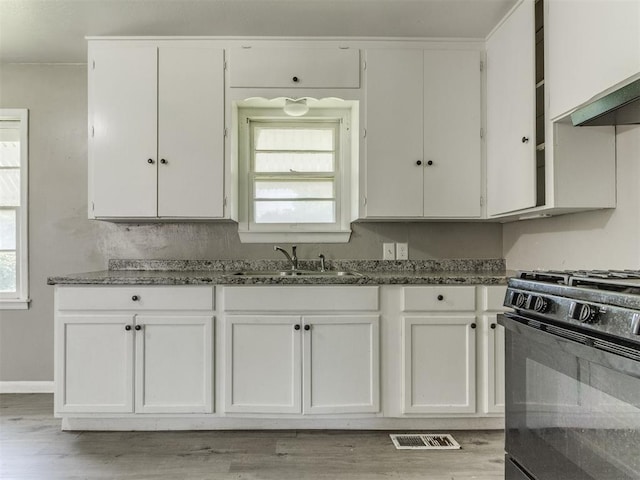 3320 NE 14th St, Oklahoma City, OK 73117 - kitchen with black gas range oven and white cabinetry