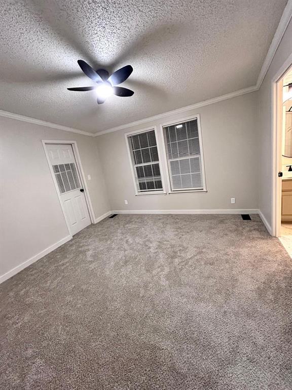 13001 Fox Pass Rd, Edmond, OK 73034 - unfurnished room featuring ceiling fan, ornamental molding, carpet flooring, and a textured ceiling