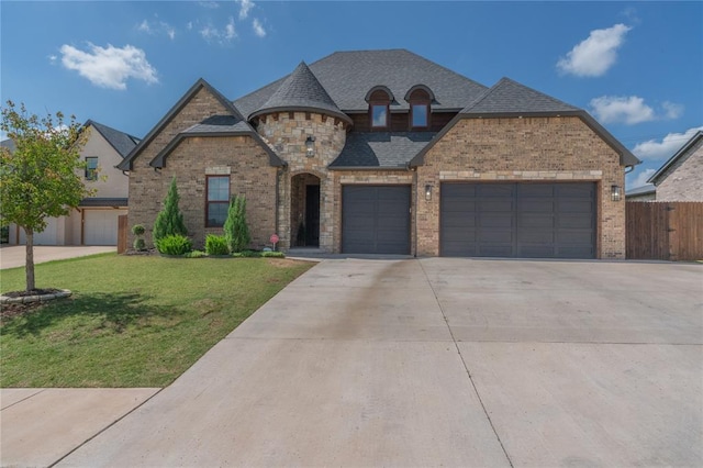 8908 NW 130th St, Oklahoma City, OK 73142 - french country style house featuring driveway, an attached garage, brick siding, and roof with shingles