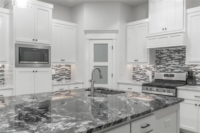 8908 NW 130th St, Oklahoma City, OK 73142 - kitchen with built in microwave, stainless steel range oven, white cabinetry, and decorative backsplash
