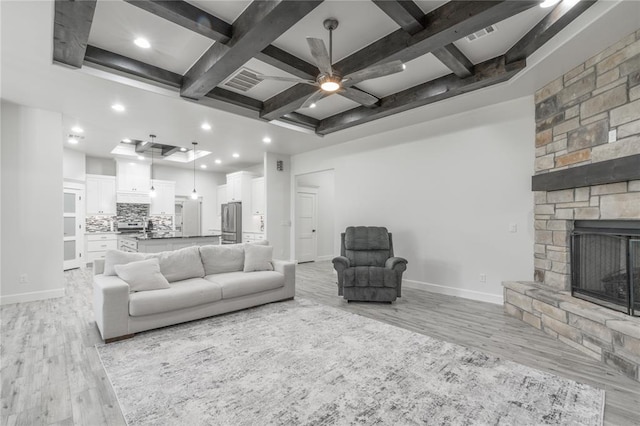 8908 NW 130th St, Oklahoma City, OK 73142 - living room featuring coffered ceiling, light wood-style flooring, a ceiling fan, beam ceiling, and a stone fireplace