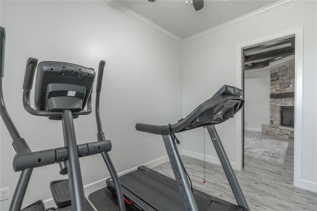 8908 NW 130th St, Oklahoma City, OK 73142 - workout area featuring crown molding, a ceiling fan, a stone fireplace, and light wood finished floors
