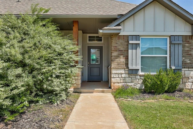 4213 NW 155th St, Edmond, OK 73013 - doorway to property featuring a shingled roof, board and batten siding, and stone siding