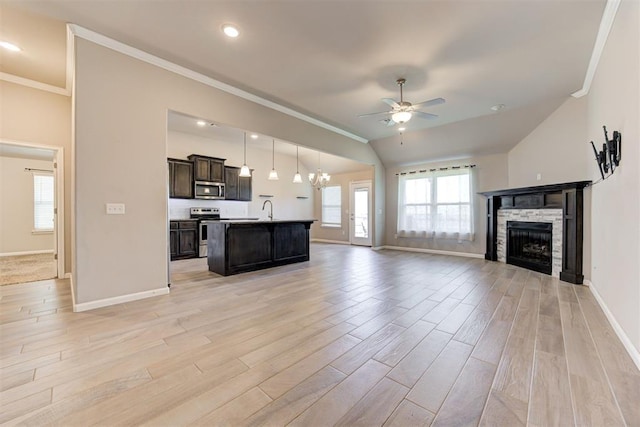 4213 NW 155th St, Edmond, OK 73013 - unfurnished living room with a ceiling fan, crown molding, a fireplace, light wood-style floors, and a chandelier