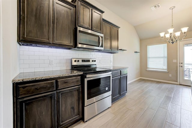 4213 NW 155th St, Edmond, OK 73013 - kitchen with stainless steel appliances, a chandelier, stone countertops, vaulted ceiling, and tasteful backsplash