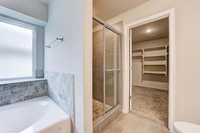 4213 NW 155th St, Edmond, OK 73013 - full bathroom featuring a walk in closet, a shower stall, a bath, and tile patterned flooring