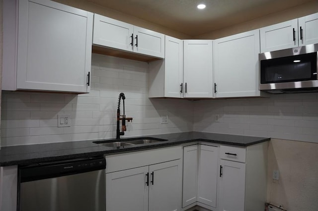 3309 SW 27th St, Oklahoma City, OK 73108 - kitchen with stainless steel appliances, white cabinets, decorative backsplash, dark stone countertops, and recessed lighting