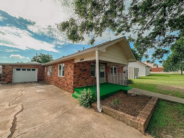 309 N Spencer Ave, Hinton, OK 73047 - view of front facade featuring brick siding, a front lawn, an attached garage, and driveway
