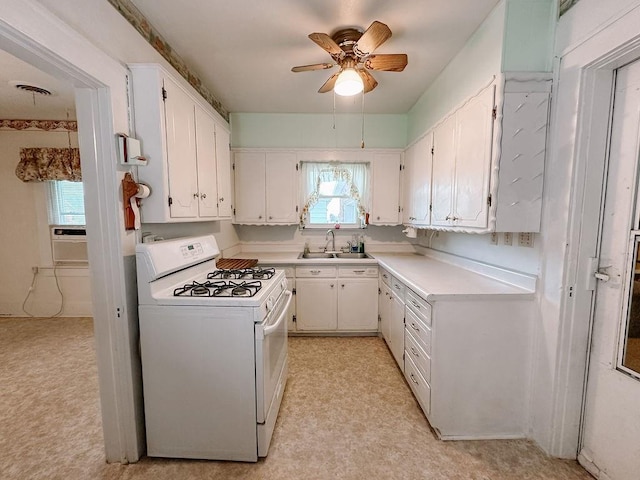 309 N Spencer Ave, Hinton, OK 73047 - kitchen with white gas stove, white cabinets, a ceiling fan, and light countertops