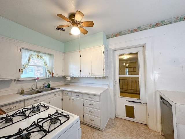 309 N Spencer Ave, Hinton, OK 73047 - kitchen with white gas stove, stainless steel dishwasher, ceiling fan, light countertops, and white cabinets