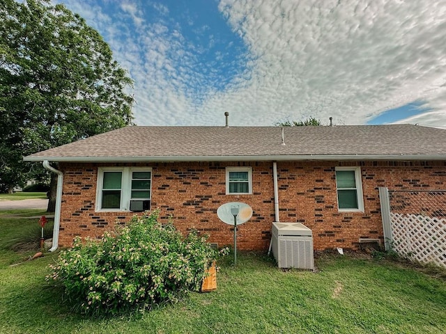 309 N Spencer Ave, Hinton, OK 73047 - view of home's exterior with roof with shingles, a lawn, and brick siding