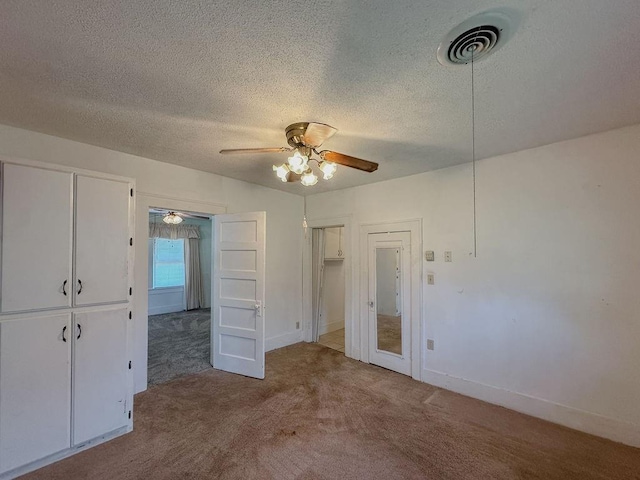 309 N Spencer Ave, Hinton, OK 73047 - unfurnished bedroom with carpet flooring, a textured ceiling, and ceiling fan